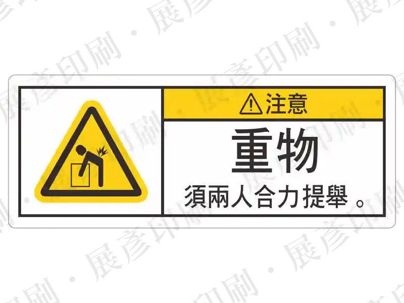 左側黃色警告三角(重物),右側黃底「注 意」,文字「重物 須兩人合力提舉。」。用途:重物搬運警示。語系:繁中