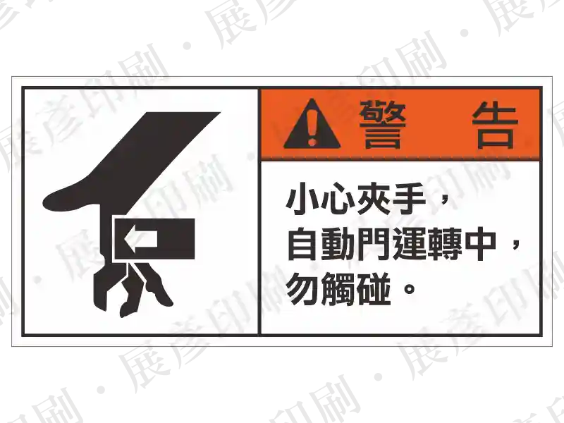 左側為手部碰觸圖示,右上橘底「警 告」,右下「小心夾手,自動門運轉中,勿觸碰。」。用途:自動門夾手警示。語系:繁中