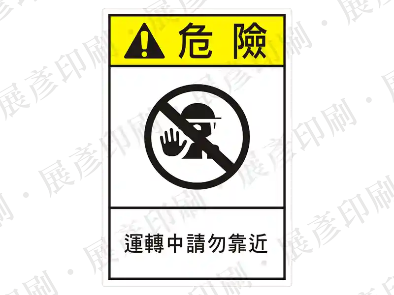 直式長方形,上方黃色警告圖示(禁止進入),下方文字「運轉中請勿靠近」。用途:運轉中禁止靠近警示。語系:繁中