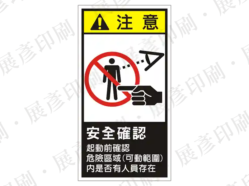 直式長方形,上方為禁止進入圖示,中間黑底「注 意」,下方文字「安全確認 起動前確認 危險區域(可動範圍)內是否有人員存在」。用途:啟動前安全確認警示。語系:繁中