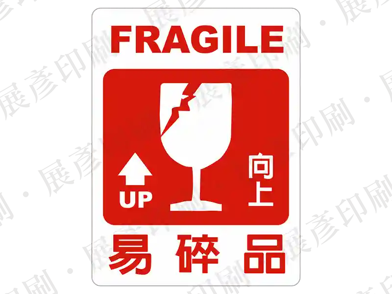 紅底白圖，酒杯破碎與向上箭頭圖示，文字「FRAGILE 易碎品 UP 向上」。用途：易碎品警示。語系：繁中/英文