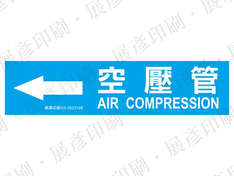 藍底白字,左側箭頭,文字「空壓管 AIR COMPRESSION」。用途:空壓管路標示流向。語系:繁中/英文