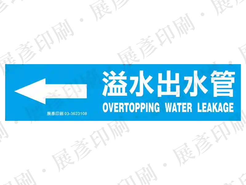 藍底白字,左側箭頭,文字「溢水出水管 OVERTOPPING WATER LEAKAGE」。用途:溢水出水管路標示流向。語系:繁中/英文