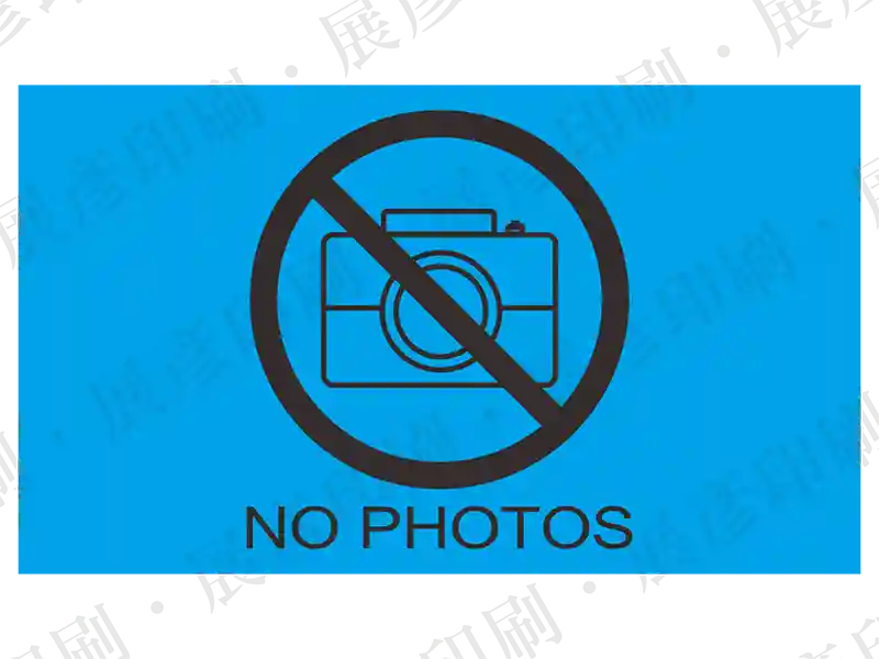 藍底黑色禁止照相圖示，文字「NO PHOTOS」。撕開不留殘膠。用途：手機鏡頭/機密場所防護。語系：英文